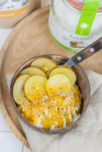 Porridge mit Goldener Milch in Kokosnussschale von bioKontor